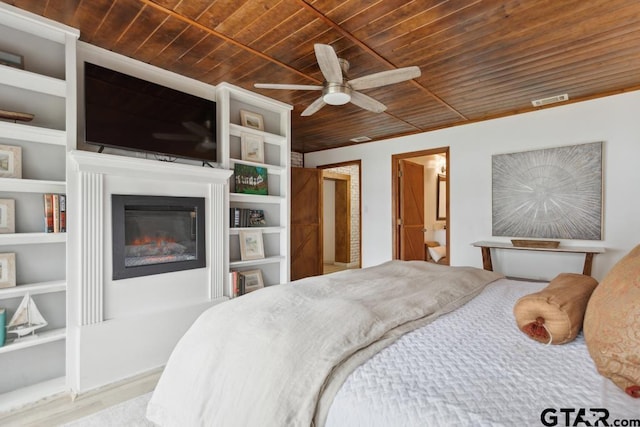 11020 Kevin Dr, Frankston, TX 75763 - bedroom with wood ceiling, a glass covered fireplace, ceiling fan, and wood finished floors