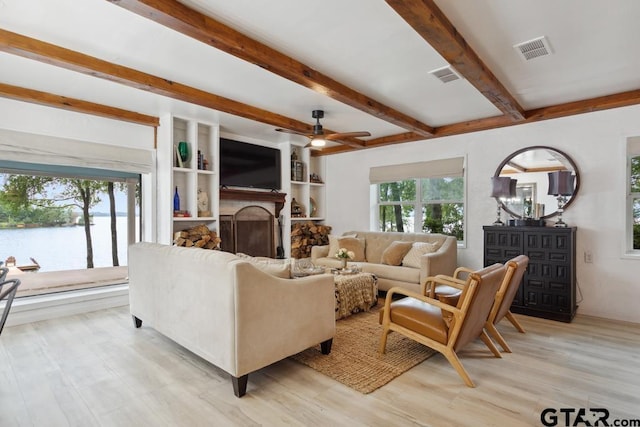 11020 Kevin Dr, Frankston, TX 75763 - living area featuring a ceiling fan, beamed ceiling, a fireplace, light wood finished floors, and a water view