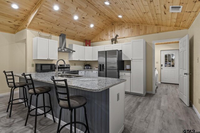 2106 Fm 1647, Winnsboro, TX 75494 - kitchen featuring visible vents, a sink, stainless steel appliances, a peninsula, and wall chimney exhaust hood