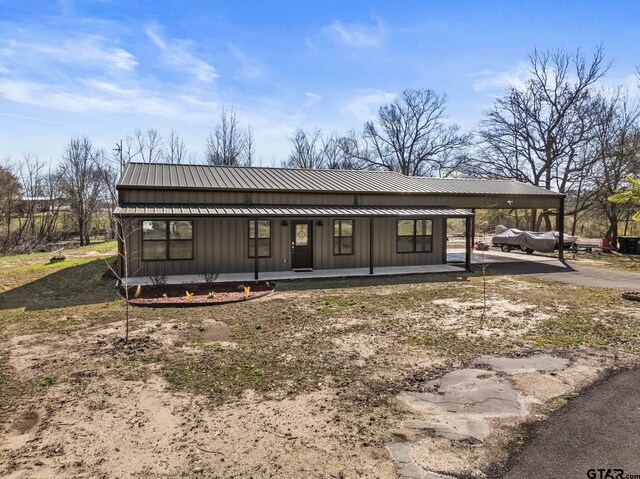 2106 Fm 1647, Winnsboro, TX 75494 - back of property featuring metal roof, covered porch, board and batten siding, and a standing seam roof