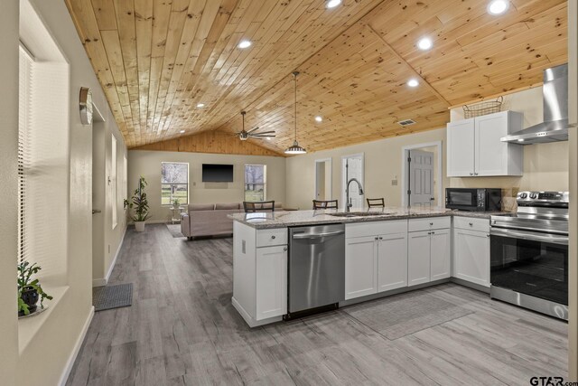 2106 Fm 1647, Winnsboro, TX 75494 - kitchen featuring a sink, white cabinetry, stainless steel appliances, a peninsula, and wall chimney exhaust hood