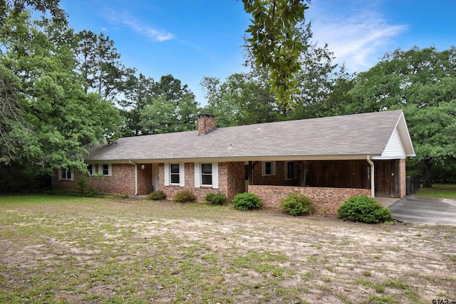 single story home with a front lawn and a carport