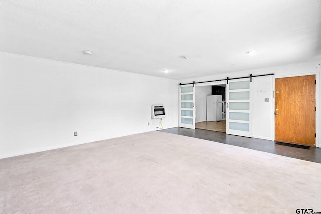 spare room featuring heating unit and a barn door
