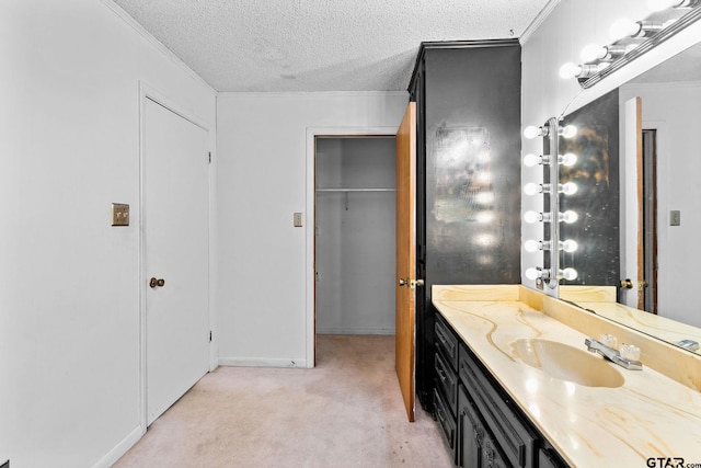 bathroom featuring ornamental molding, vanity, and a textured ceiling
