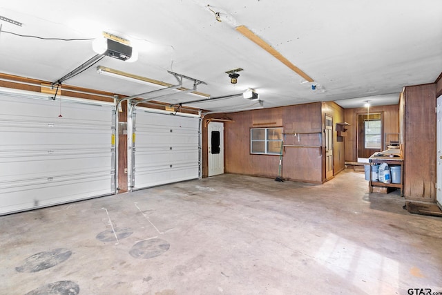 garage featuring wooden walls and a garage door opener