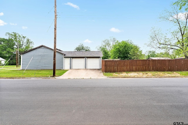 garage with fence and driveway