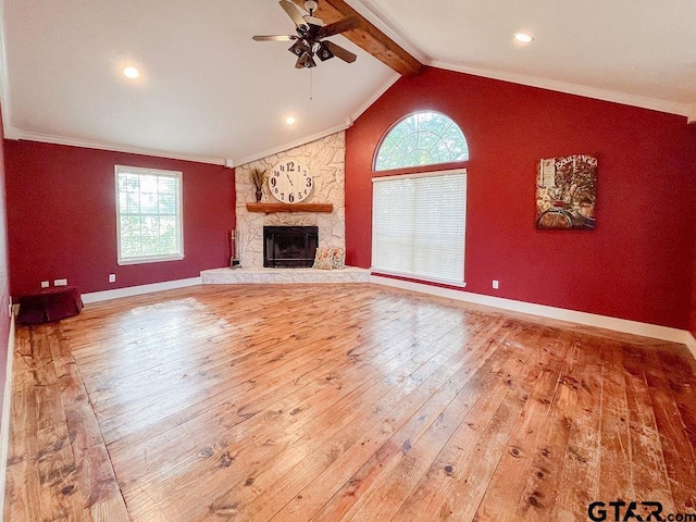 unfurnished living room with a wealth of natural light, wood-type flooring, crown molding, and lofted ceiling with beams