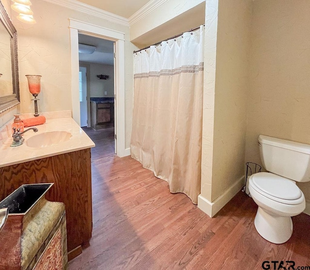 bathroom featuring ornamental molding, vanity, hardwood / wood-style flooring, and toilet