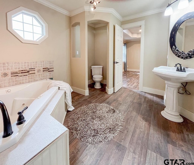 bathroom featuring crown molding, hardwood / wood-style floors, toilet, and a tub