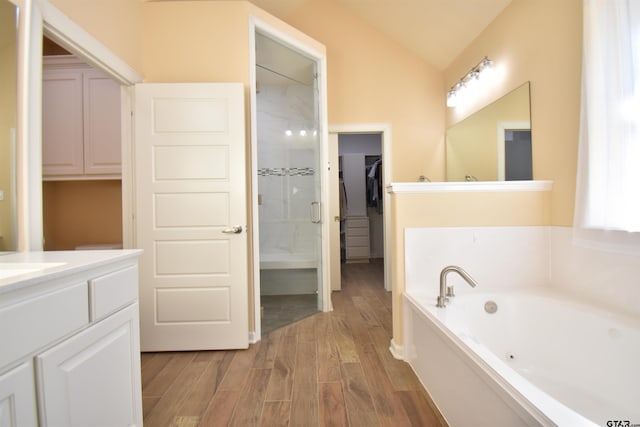 2222 Rana Park, Flint, TX 75762 - bathroom with vanity, wood finished floors, vaulted ceiling, a bath, and a stall shower