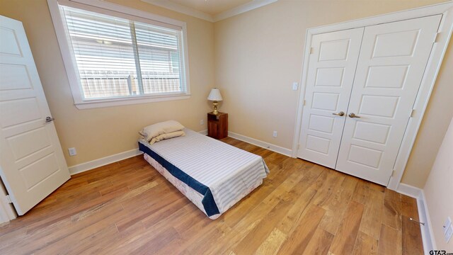 2222 Rana Park, Flint, TX 75762 - bedroom with baseboards, light wood-type flooring, ornamental molding, and a closet