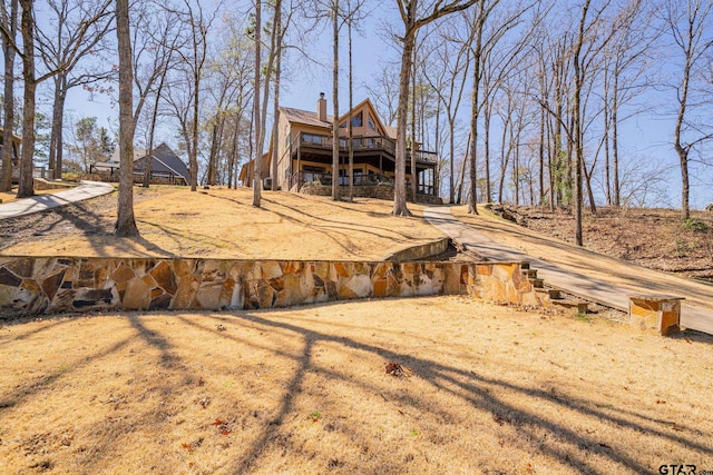 rear view of property featuring a deck and a chimney