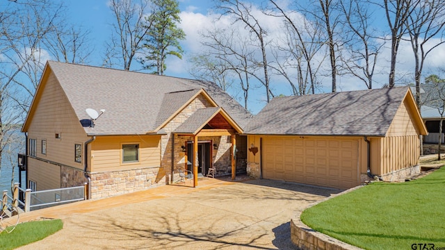 rustic home with a garage, stone siding, driveway, and roof with shingles