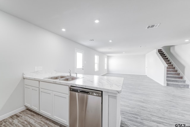 kitchen with sink, white cabinets, stainless steel dishwasher, kitchen peninsula, and light colored carpet