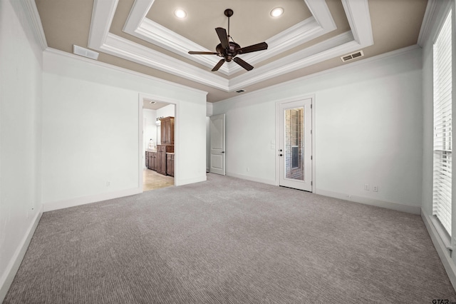 unfurnished room with ornamental molding, light colored carpet, ceiling fan, and a raised ceiling