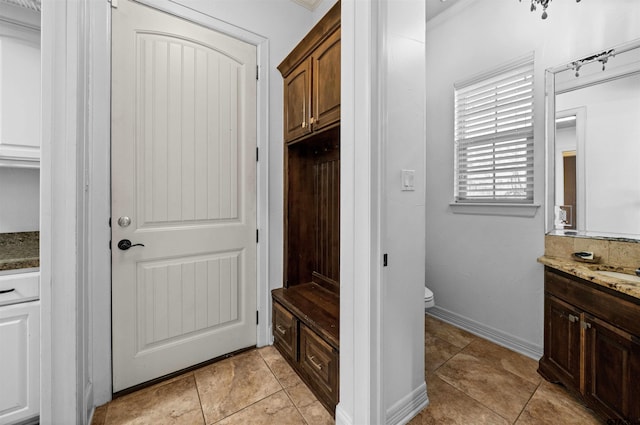 mudroom featuring light tile patterned flooring and ornamental molding