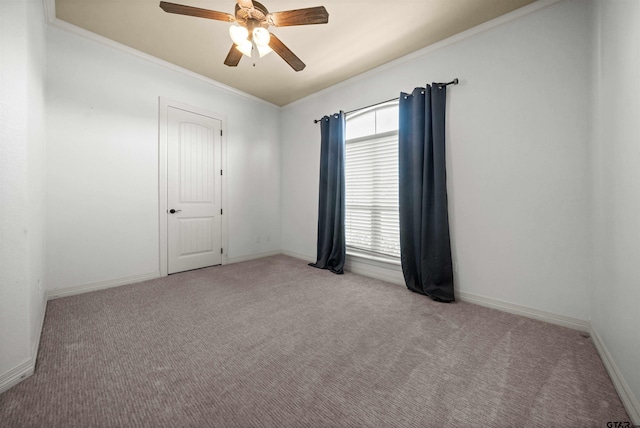 spare room featuring light carpet, ceiling fan, and crown molding