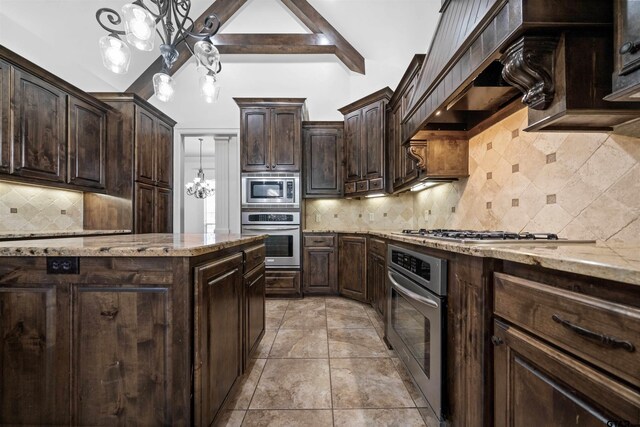 21882 Syrah Dr, Tyler, TX 75703 - kitchen featuring stainless steel appliances, tasteful backsplash, dark brown cabinets, light stone counters, and pendant lighting