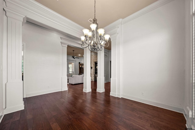 unfurnished dining area featuring ceiling fan with notable chandelier, dark hardwood / wood-style floors, ornate columns, and crown molding