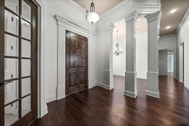 entryway featuring dark hardwood / wood-style flooring, decorative columns, an inviting chandelier, and crown molding