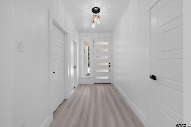 entryway with light hardwood / wood-style flooring and an inviting chandelier