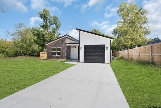 view of front of home with a garage and a front lawn