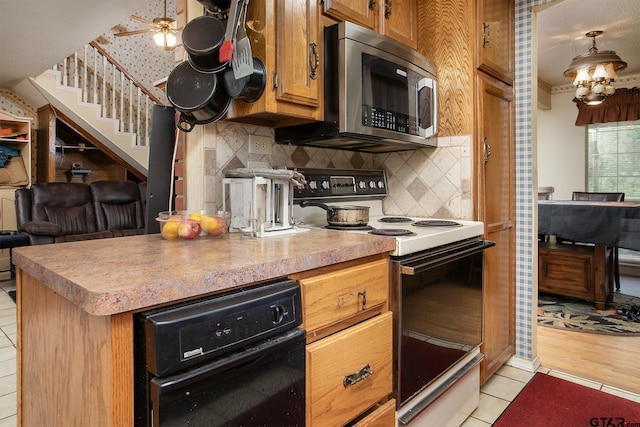 811 Janis, Bullard, TX 75757 - kitchen featuring stainless steel microwave, electric range, light tile patterned floors, backsplash, and brown cabinets