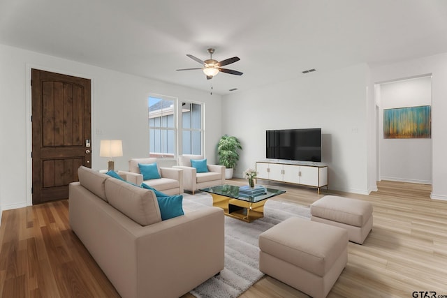 living room with ceiling fan and light wood-type flooring