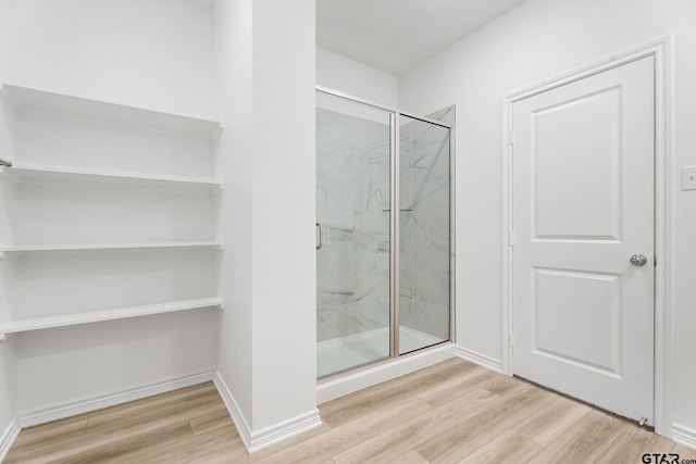 bathroom featuring hardwood / wood-style flooring and a shower with door