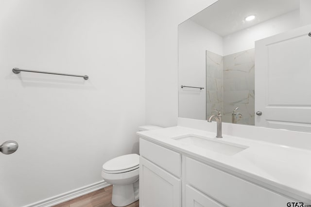 bathroom featuring wood-type flooring, a shower, vanity, and toilet