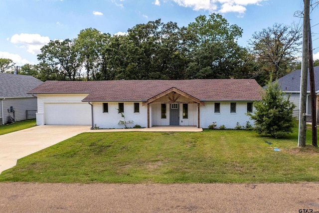 ranch-style home featuring a front yard, a garage, and covered porch