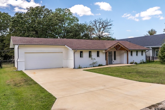 ranch-style house featuring a front yard and a garage