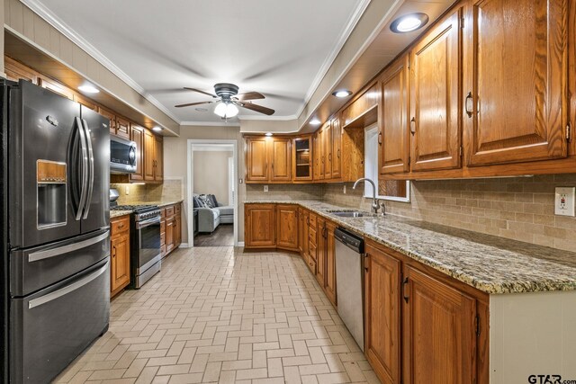 1108 Quitman, Pittsburg, TX 75686 - kitchen with stainless steel appliances, a sink, brown cabinets, brick patterned floors, and light stone counters