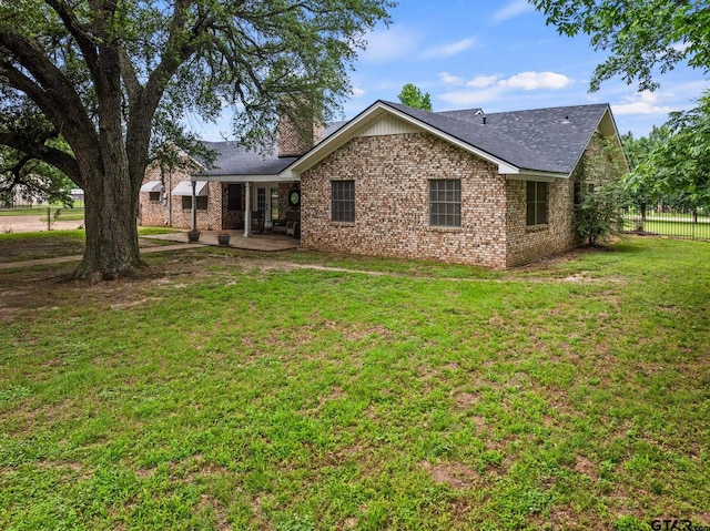 1108 Quitman, Pittsburg, TX 75686 - back of house with a patio, a chimney, and brick siding