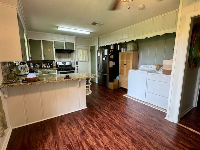 kitchen featuring appliances with stainless steel finishes, stone countertops, dark hardwood / wood-style flooring, kitchen peninsula, and independent washer and dryer