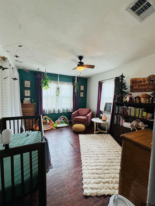 bedroom with ceiling fan, dark hardwood / wood-style floors, and a textured ceiling