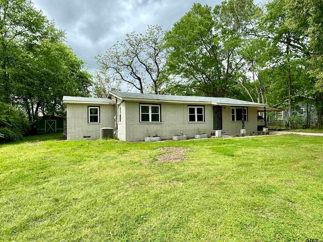 back of house featuring central AC, a yard, and a shed