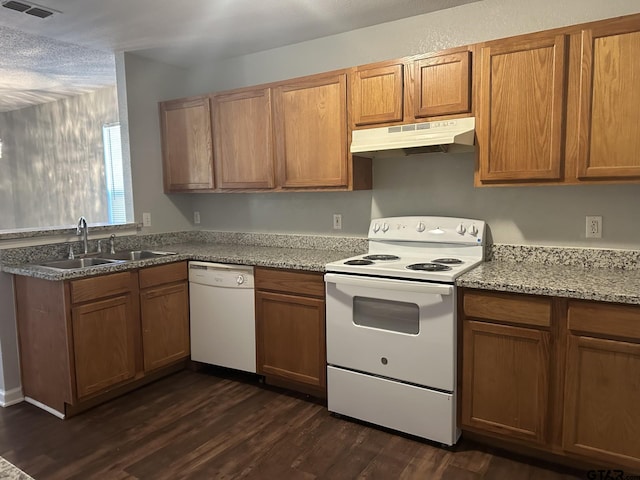 10250 Peterson Rd, Tyler, TX 75708 - kitchen with under cabinet range hood, white appliances, a sink, dark wood finished floors, and brown cabinets