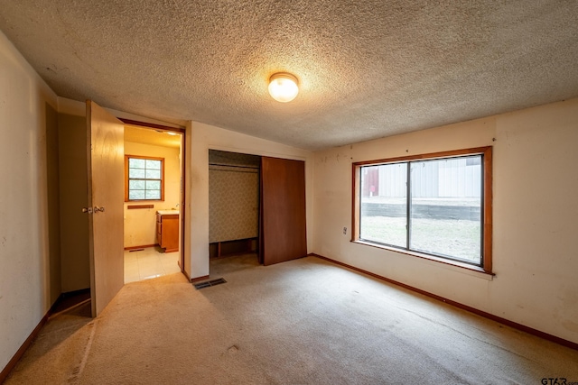 19748 Northside Dr, Winona, TX 75792 - unfurnished bedroom featuring a closet, light colored carpet, and a textured ceiling