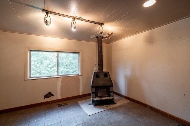 19748 Northside Dr, Winona, TX 75792 - tiled spare room with a wood stove and rail lighting