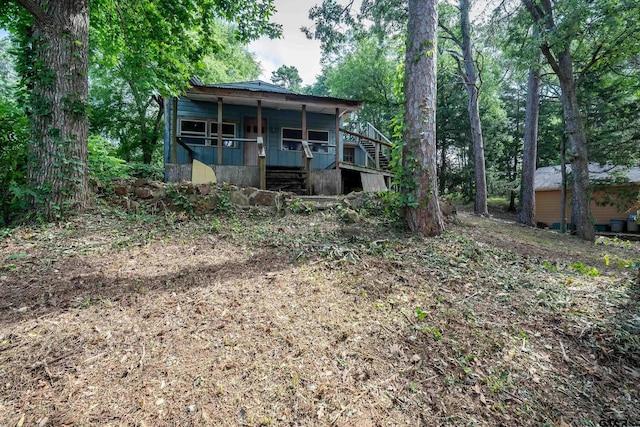 19748 Northside Dr, Winona, TX 75792 - rear view of house featuring a porch and stairway