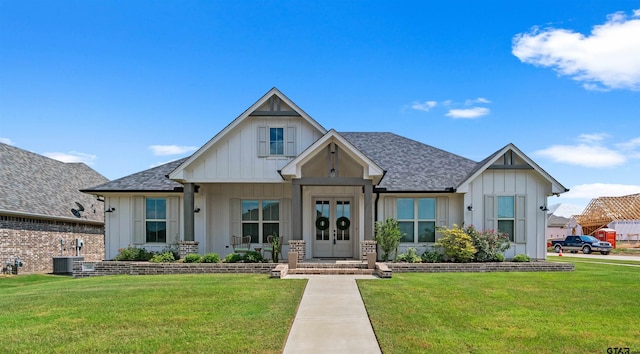 view of front of home with french doors, a front yard, and cooling unit