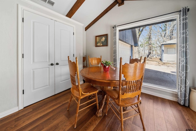 dining space with dark wood-type flooring and lofted ceiling with beams