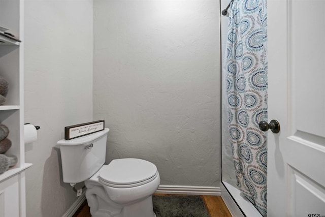 bathroom featuring wood-type flooring, toilet, and walk in shower