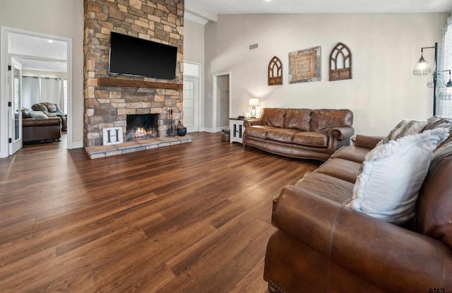 living room featuring dark hardwood / wood-style floors, a fireplace, and high vaulted ceiling