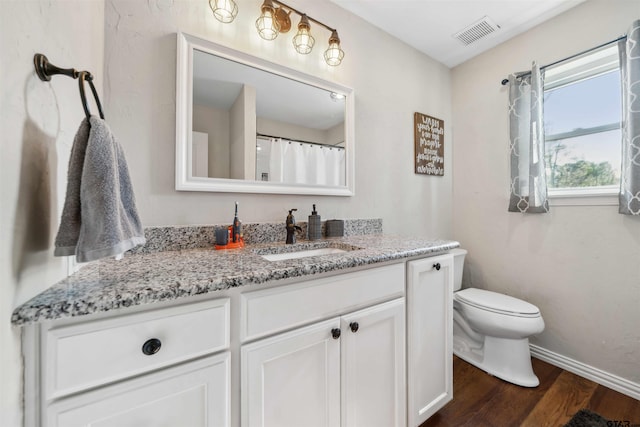 bathroom with vanity, hardwood / wood-style floors, and toilet