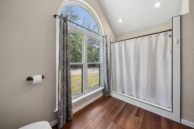 bathroom featuring wood-type flooring, lofted ceiling, and toilet