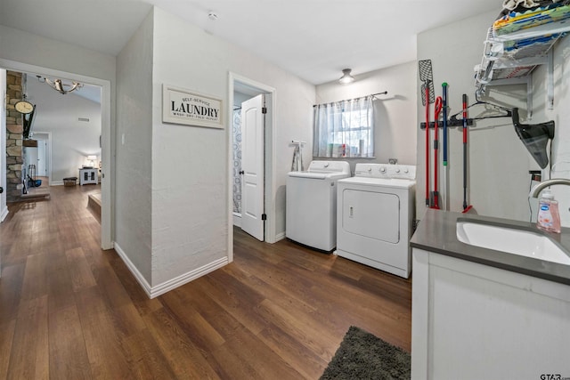 laundry room with dark hardwood / wood-style floors, sink, and independent washer and dryer