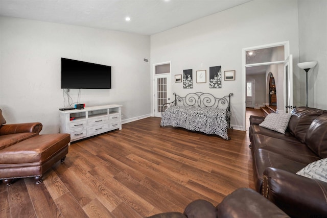 living room featuring dark hardwood / wood-style flooring and high vaulted ceiling