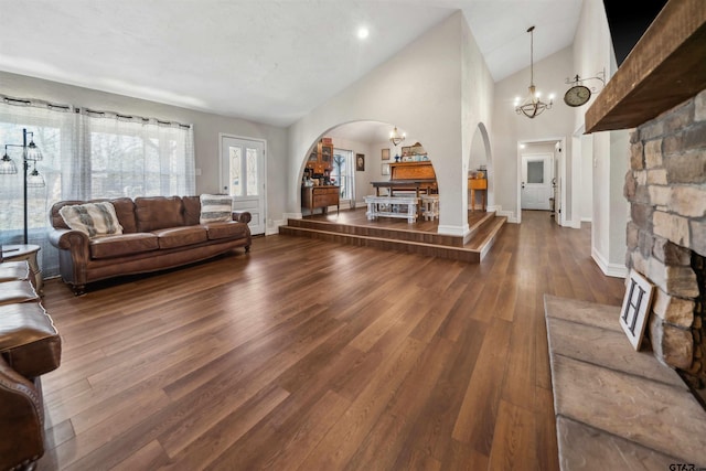 living room featuring wood-type flooring, high vaulted ceiling, and a chandelier